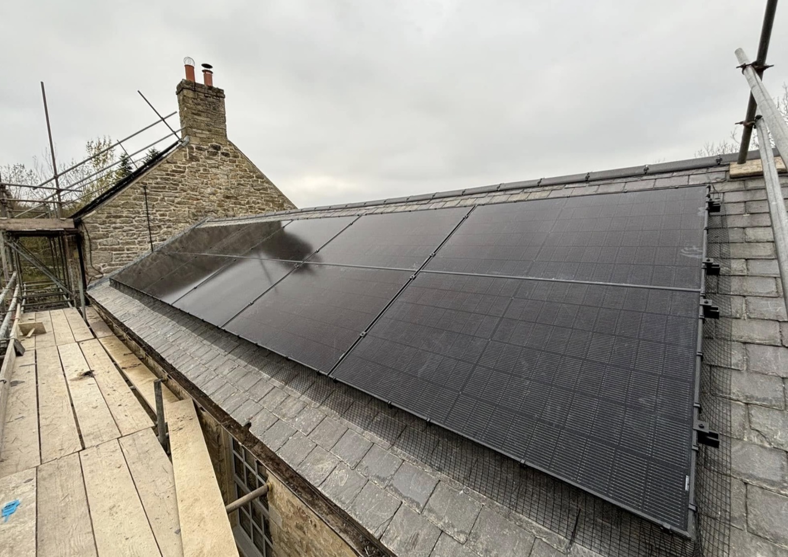 All black solar array on a stone cottage roof