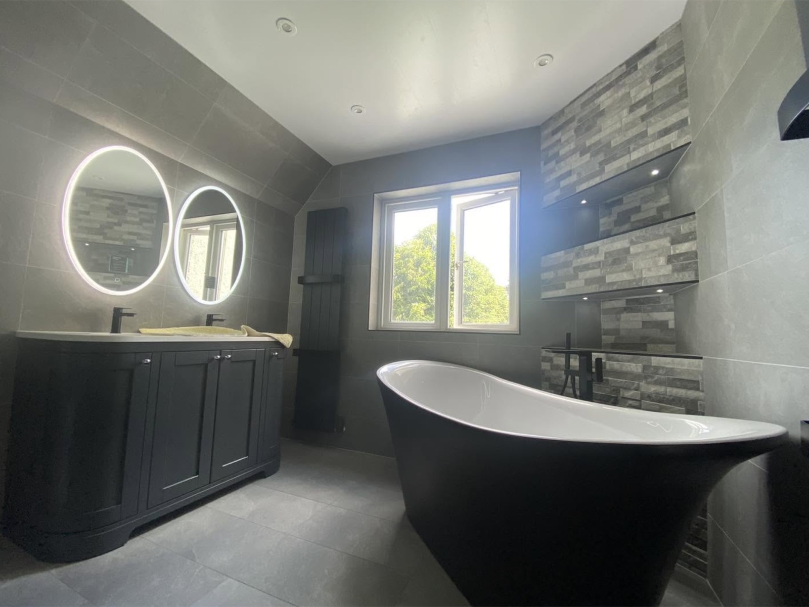 Bathroom with twin backlit mirrors and lit display shelving