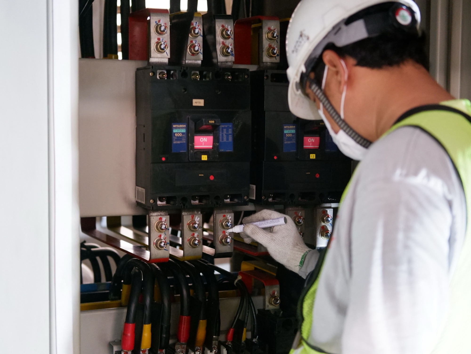 Electrician labelling breakers inside a distribution board