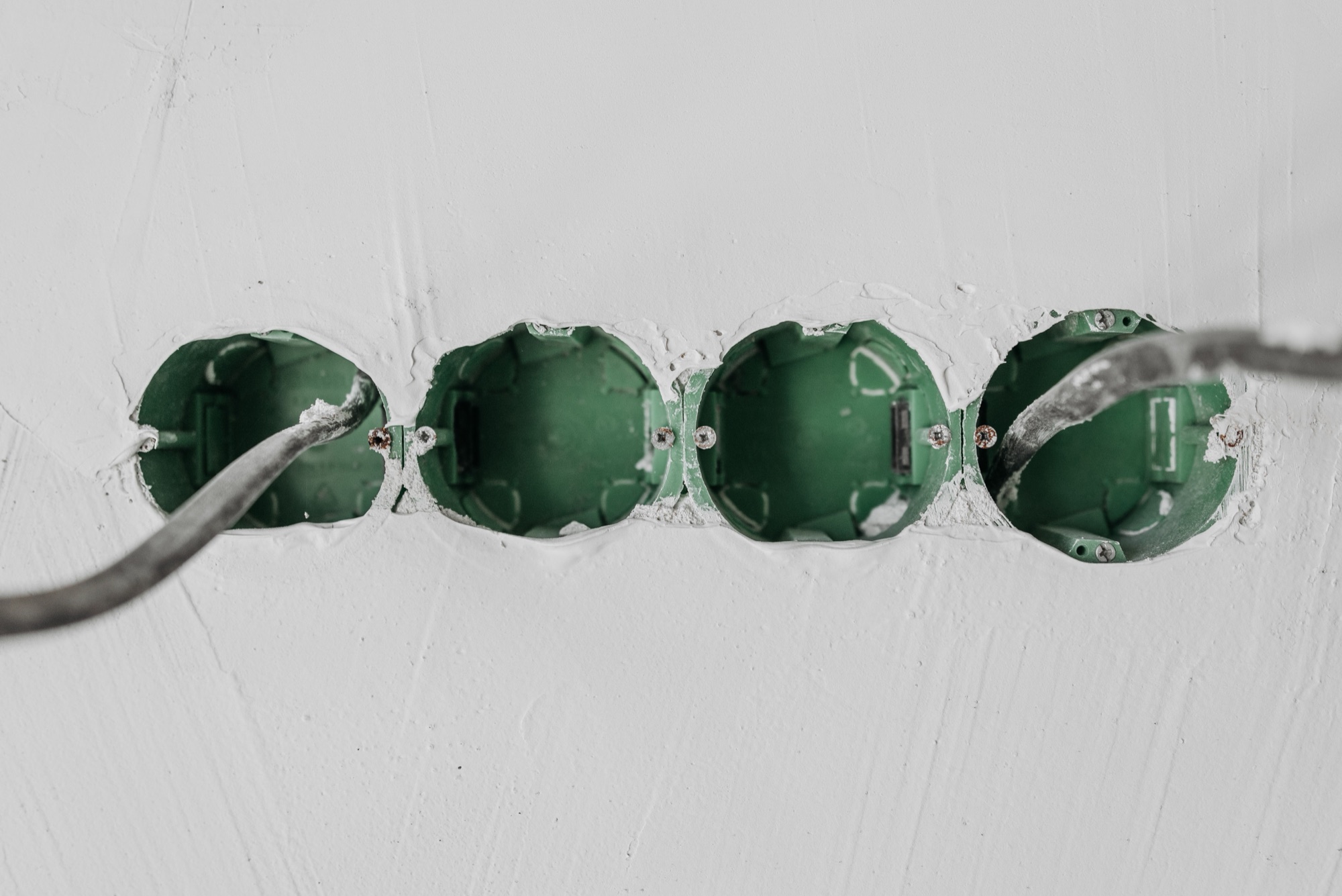 Green back boxes set into a freshly plastered wall during a rewire