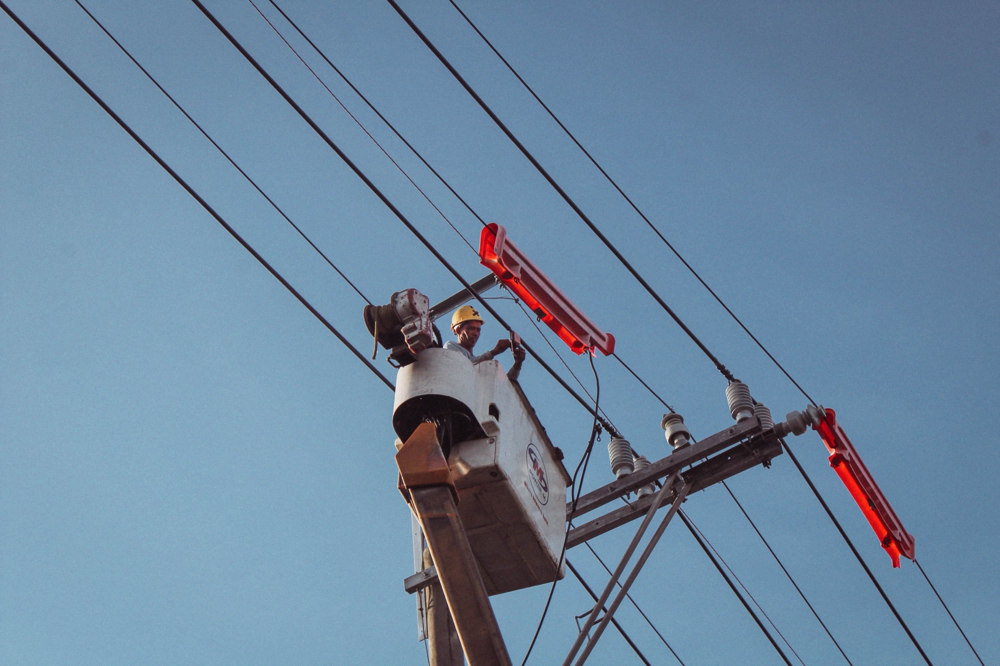 Electrician working from a bucket lift on overhead lines